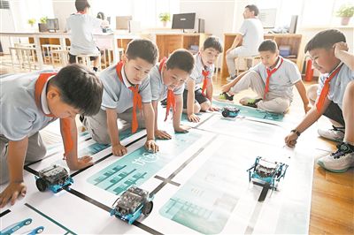 圖為中關(guān)村第三小學(xué)雄安校區(qū)編程社團(tuán)的學(xué)生檢驗(yàn)機(jī)器人的編程效果。新華社記者 李鑫攝